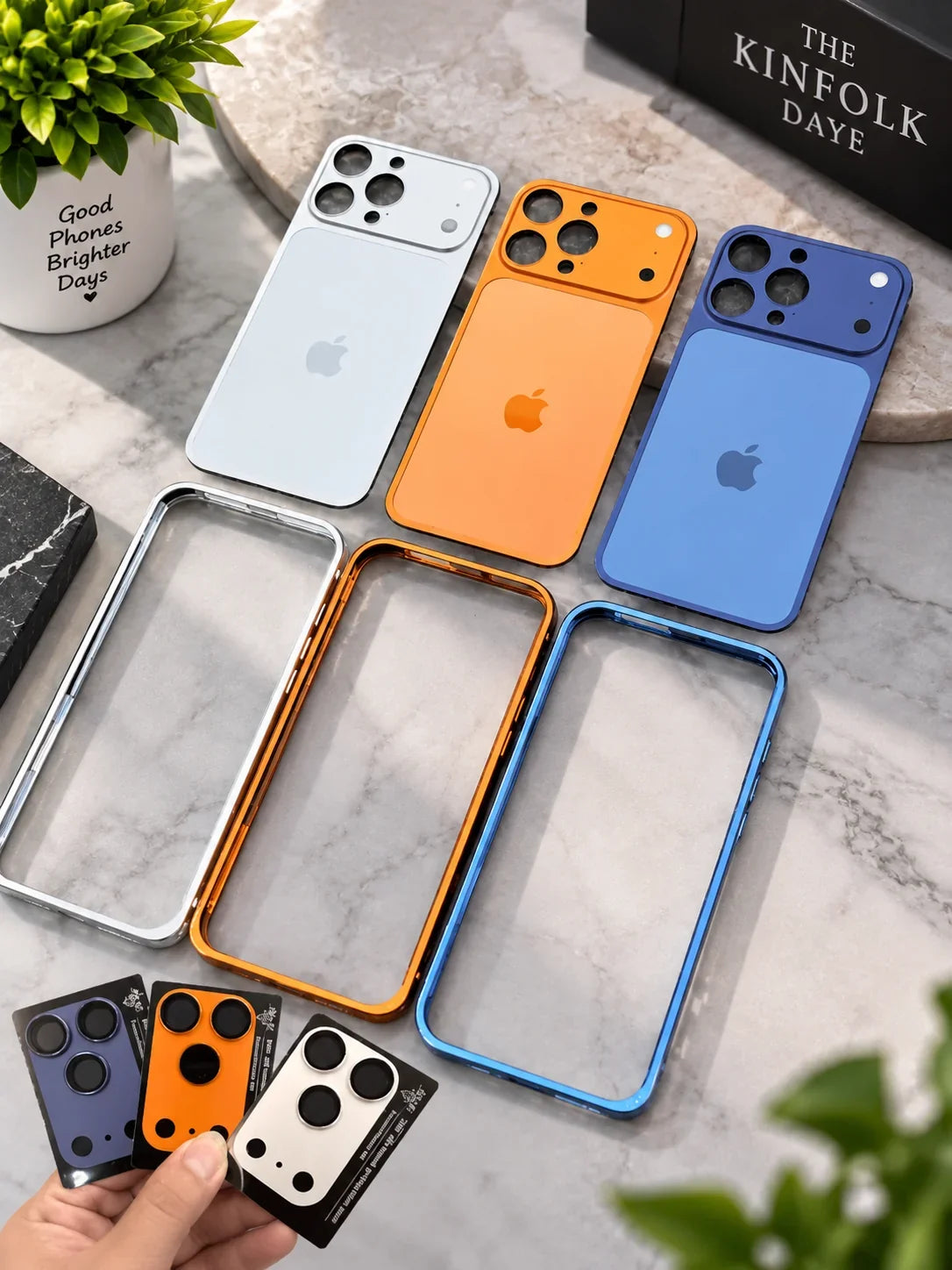 iPhone 17 converter cases in silver, orange and blue laid flat on a marble surface